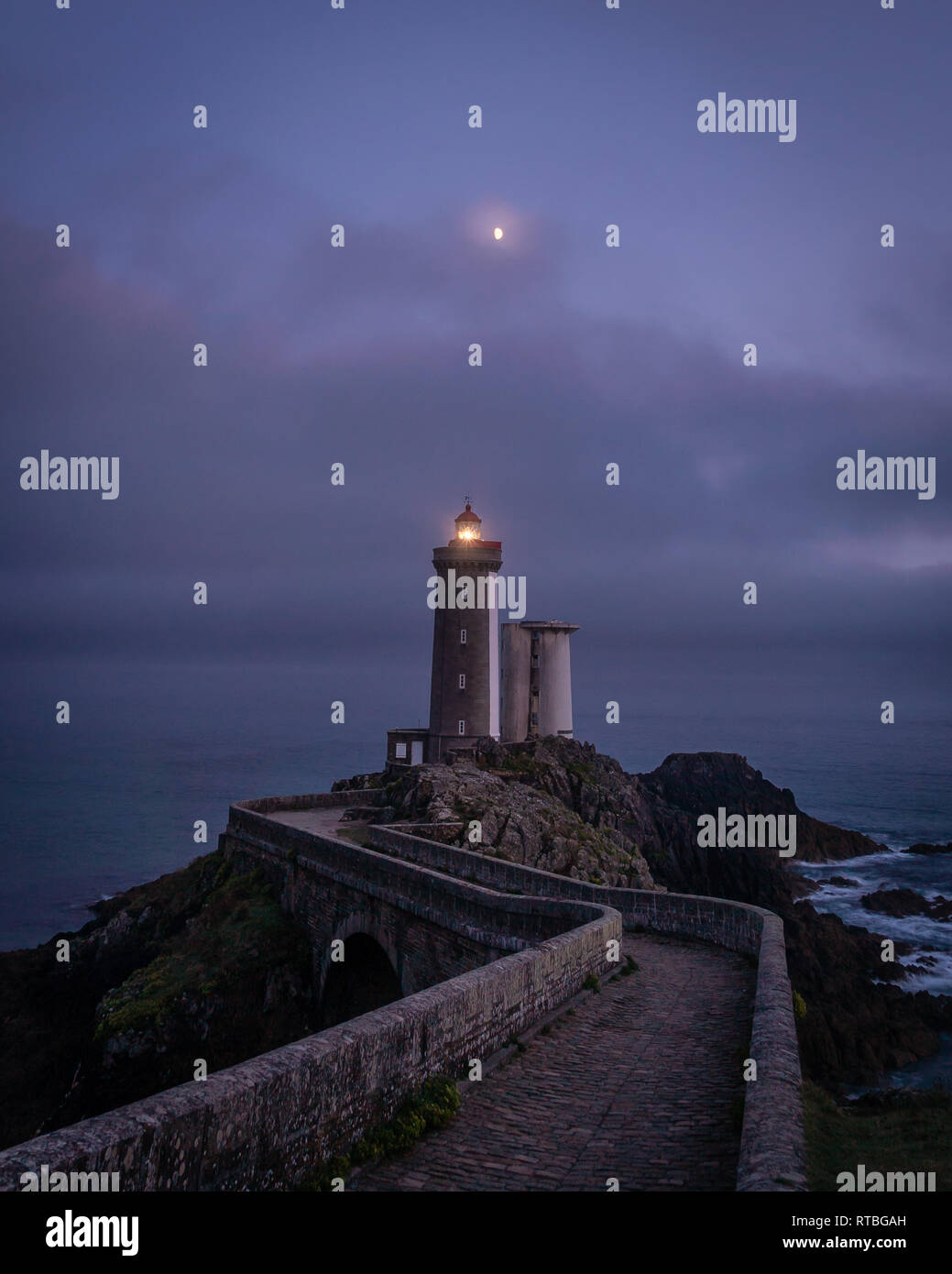 Isolated lighthouse path and moon over Petit Minou tower in France Stock Photo