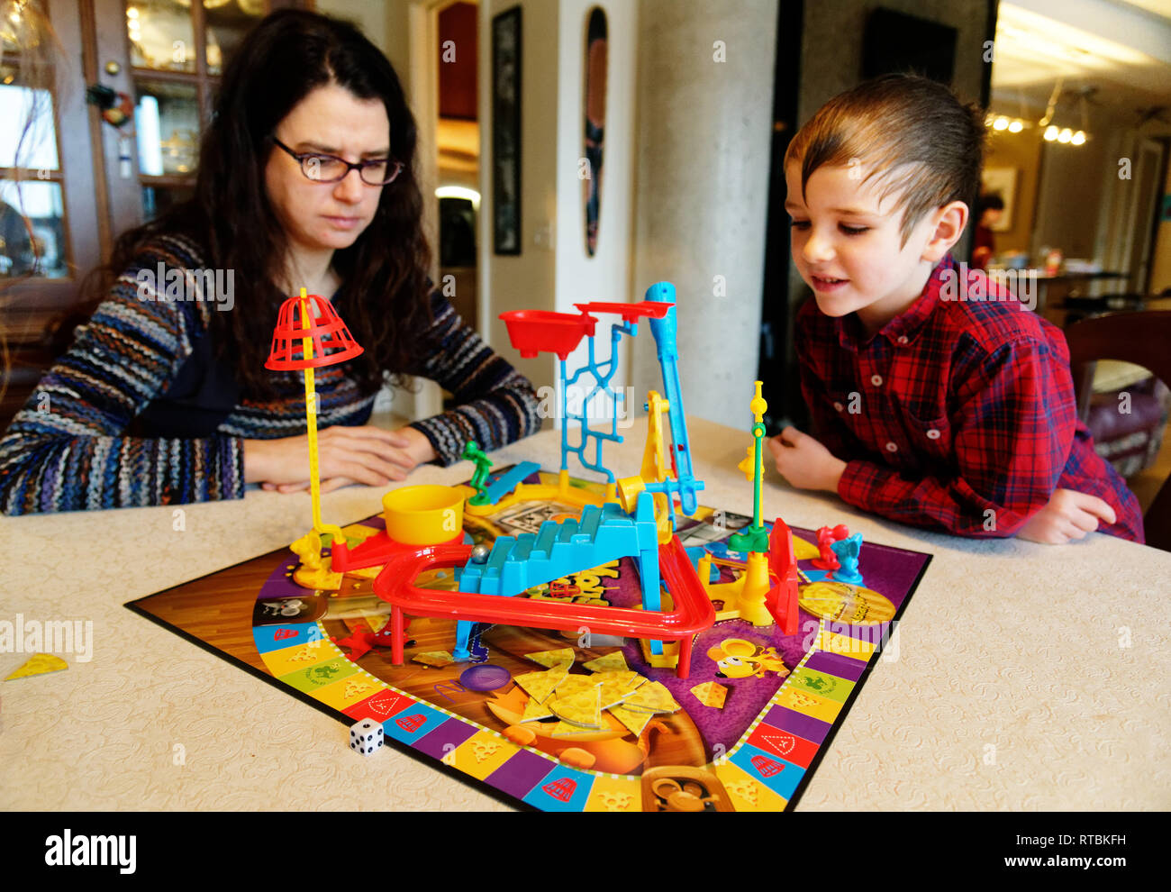 Mother and son (6 yr old) playing Mouse Trap board game Stock Photo