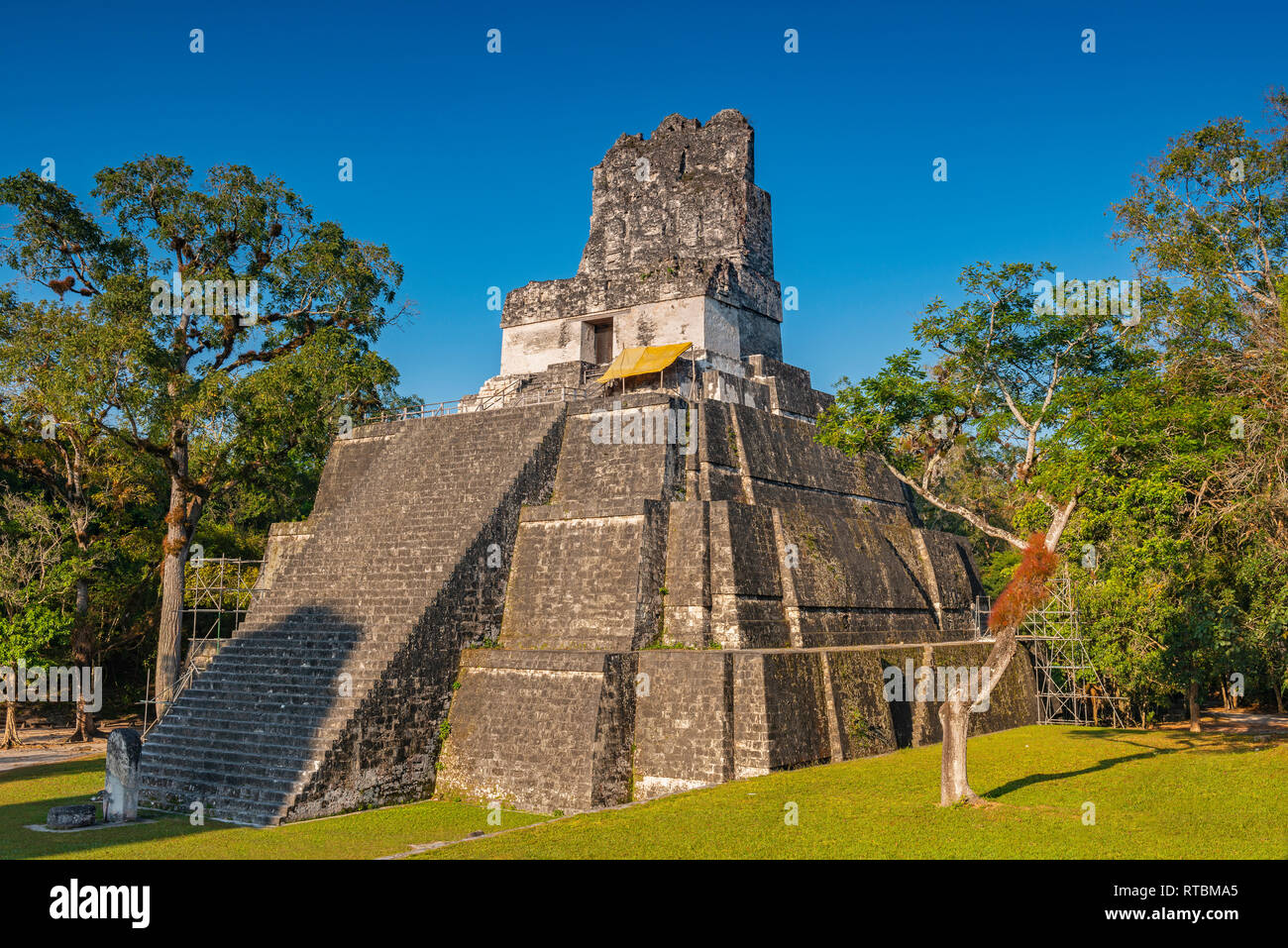 Main square of the Mayan Tikal archaeological complex with the Temple II pyramid midst of the Peten rainforest near the city of Flores, Guatemala. Stock Photo