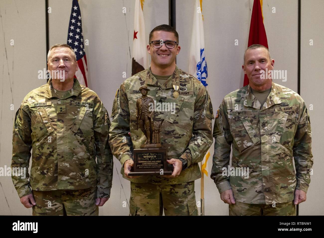 California State Military Reserve Maj. Gen. Lawrence Haskins, commander of the California Army National Guard, left, and U.S. Army Command Sgt. Maj. Scott Witt, the senior enlisted soldier in the California Army National Guard, right, present one of three trophies to Staff Sgt. Kory Simmons, of the California National Guard's 95th Civil Support Team, during the Best Warrior Luncheon, Feb. 9, 2019, in Anaheim, California. Simmons earned top honors in state's Best Warrior Competition for his performance in the unknown distance ruck march, combined day and night land navigation course, and pistol Stock Photo