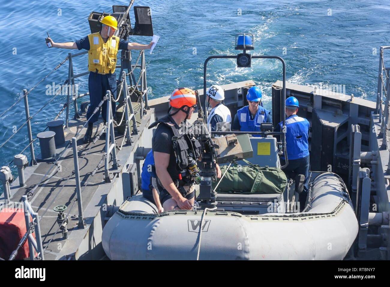 ARABIAN GULF (Feb. 9, 2019) Chief Boatswain's Mate Luichy Victorianoabrej, left, directs a rigid-hull inflatable boat exercise aboard the Cyclone-class coastal patrol ship USS Thunderbolt (PC 12). Thunderbolt is forward deployed to the U.S. 5th Fleet area of operations in support of naval operations to ensure maritime stability and security in the Central region, connecting the Mediterranean and the Pacific through the western Indian Ocean and three strategic choke points. Stock Photo