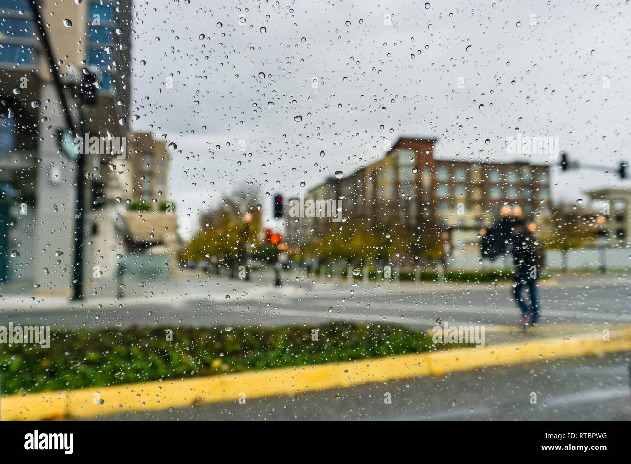 Pedestrian crossing the street on a rainy day Stock Photo - Alamy