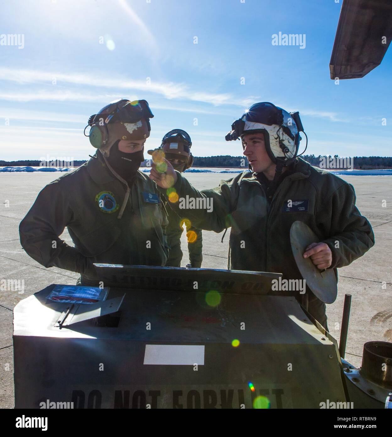 U.S. Marines discuss the utilization of a preheater to warm CH-53E Super Stallion engines in Brunswick, Maine, Feb. 11, 2019. Marine Heavy Helicopter Squadron (HMH) 464 is participating in a cold weather training exercise in Brunswick, Maine. Executing this training ensures that HMH-464 is prepared to support the Marine Air-Ground Task Force (MAGTF) commander during all phases of expeditionary operations. The Marines are assigned to HMH-464, Marine Aircraft Group 29, 2nd Marine Aircraft Wing. Stock Photo