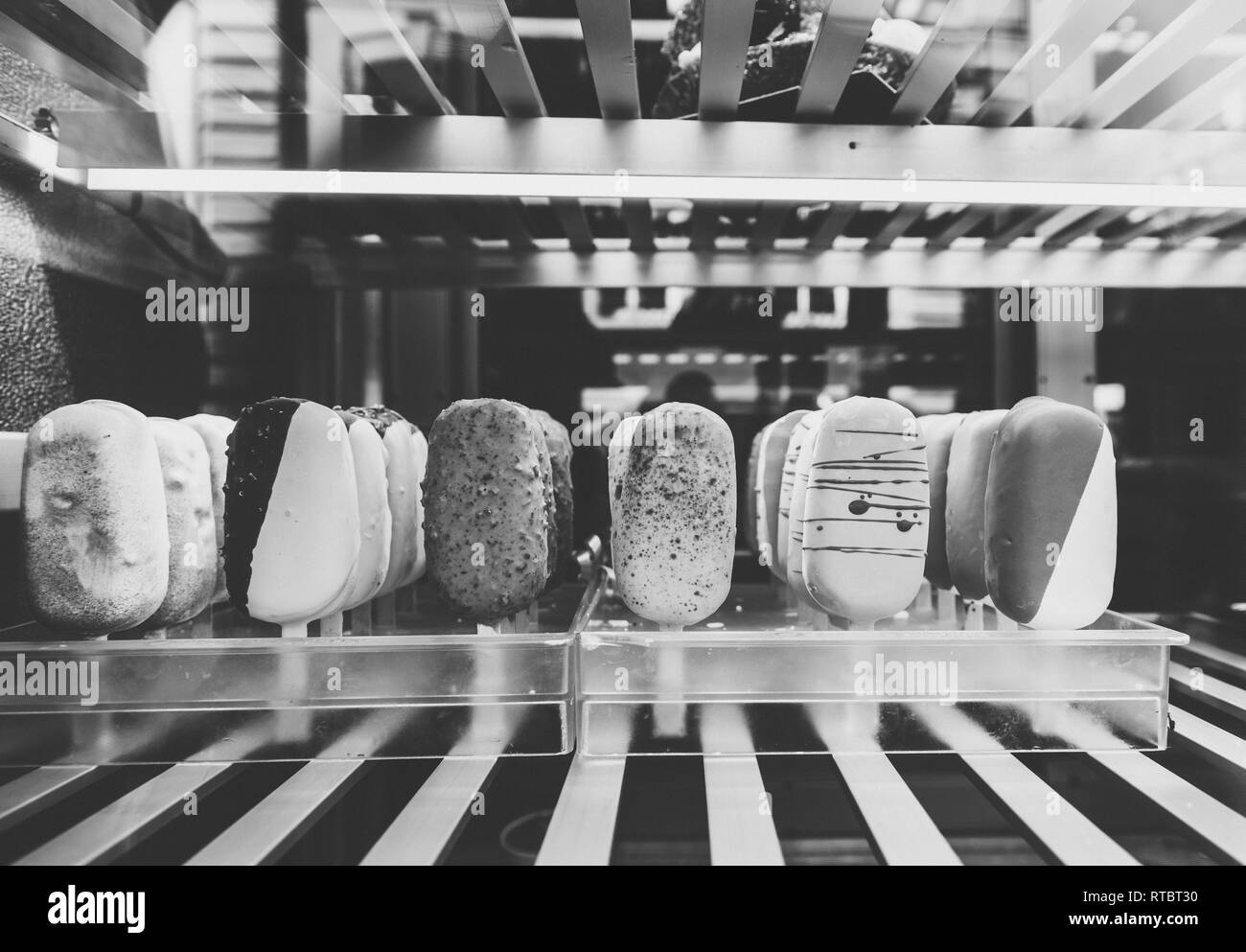 Italian ice cream shop in diverse multicolored flavors made from organic ingredients in showcase window of a traditional vintage icecream shop black and white  Stock Photo