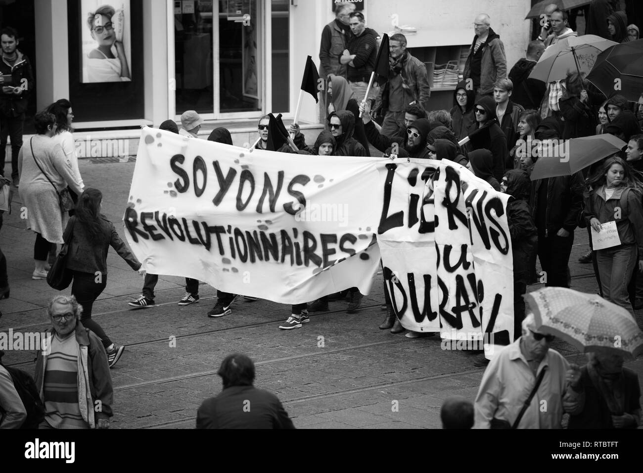 STRASBOURG, FRANCE - SEPT 12, 2017: Soyons Revolutionnaires translated as Be Revolutionary poster by incognito young people at French Nationwide day of protest against the labor reform proposed by Emmanuel Macron Government Stock Photo