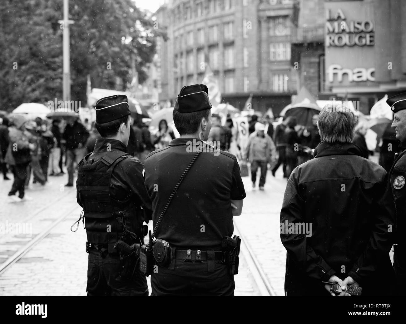 STRASBOURG, FRANCE - SEPT 12, 2017: Police under rain surveillance of people at political march during a French Nationwide day of protest against the labor reform proposed by Emmanuel Macron Government Stock Photo