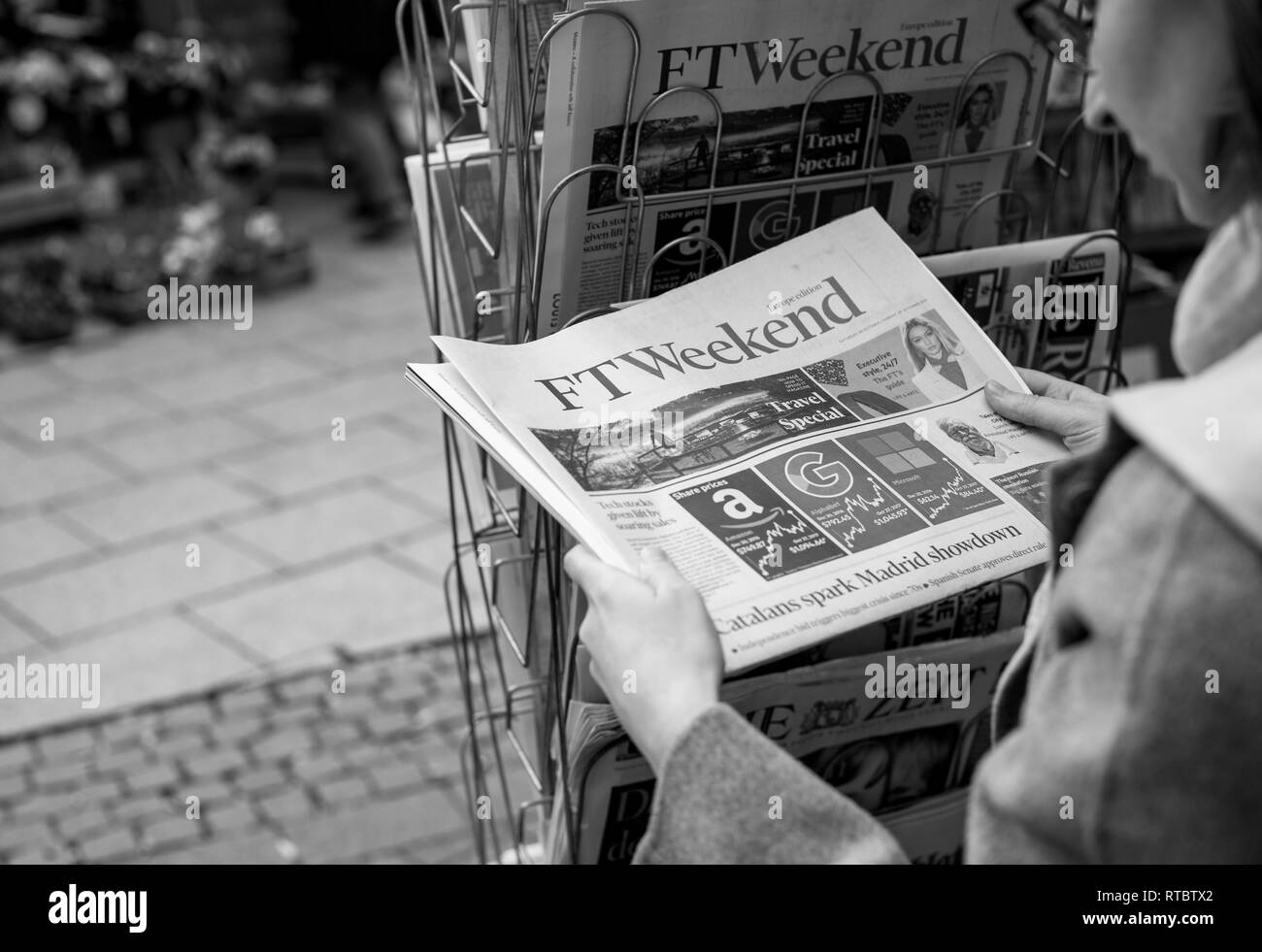 STRASBOURG, FRANCE - OCT 28, 2017: Woman buying Financial Times Weekend newspaper at press kiosk featuring  stock market tech and Catalan referendum news Stock Photo