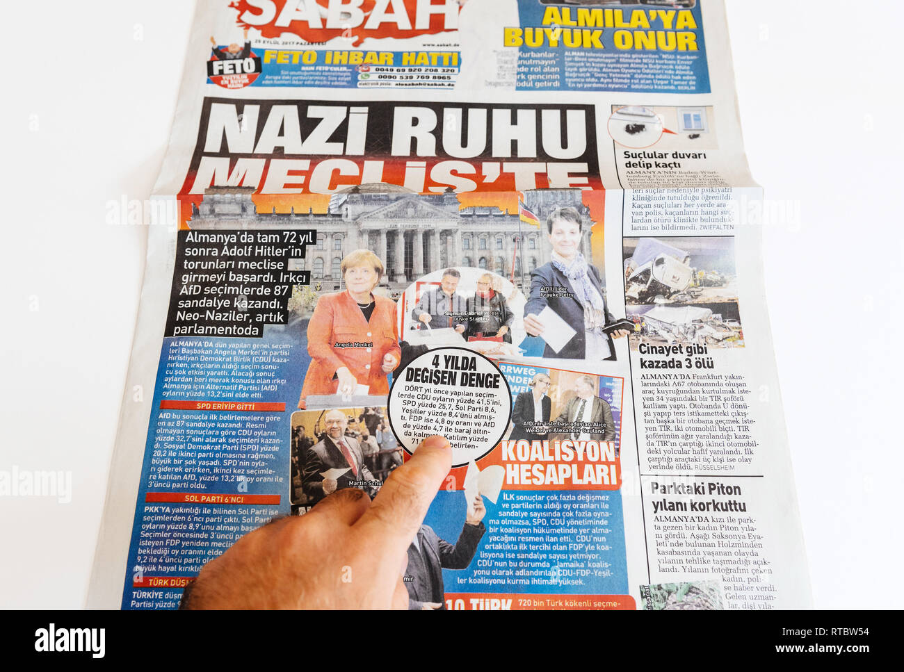 PARIS, FRANCE - SEP 25, 2017: Man reading Turkish Sabah newspaper about elections in Germany with the title 'in the nazi spirit parliament' Stock Photo