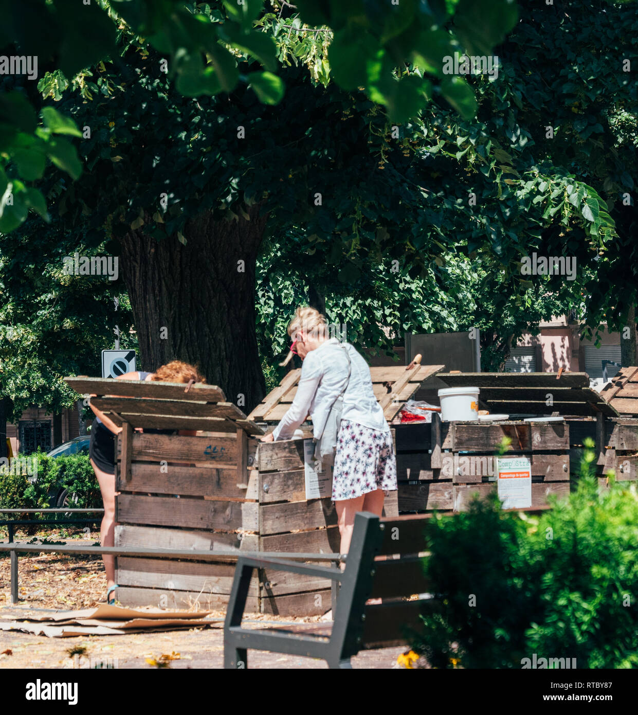 PARIS, FRANCE JUN 24 2017 Adult women composting in urban environment in dedicated spaces in
