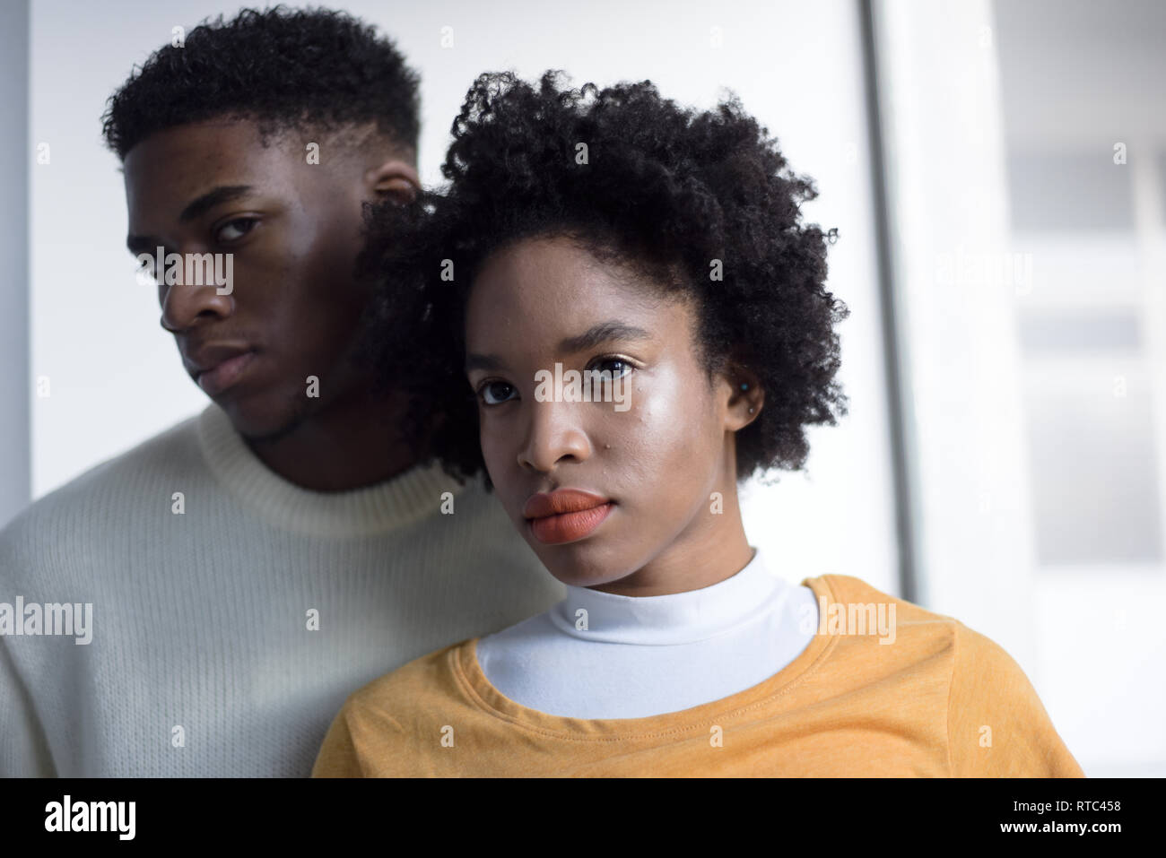A Young Attractive Black Couple Looking Serious In A Simple White
