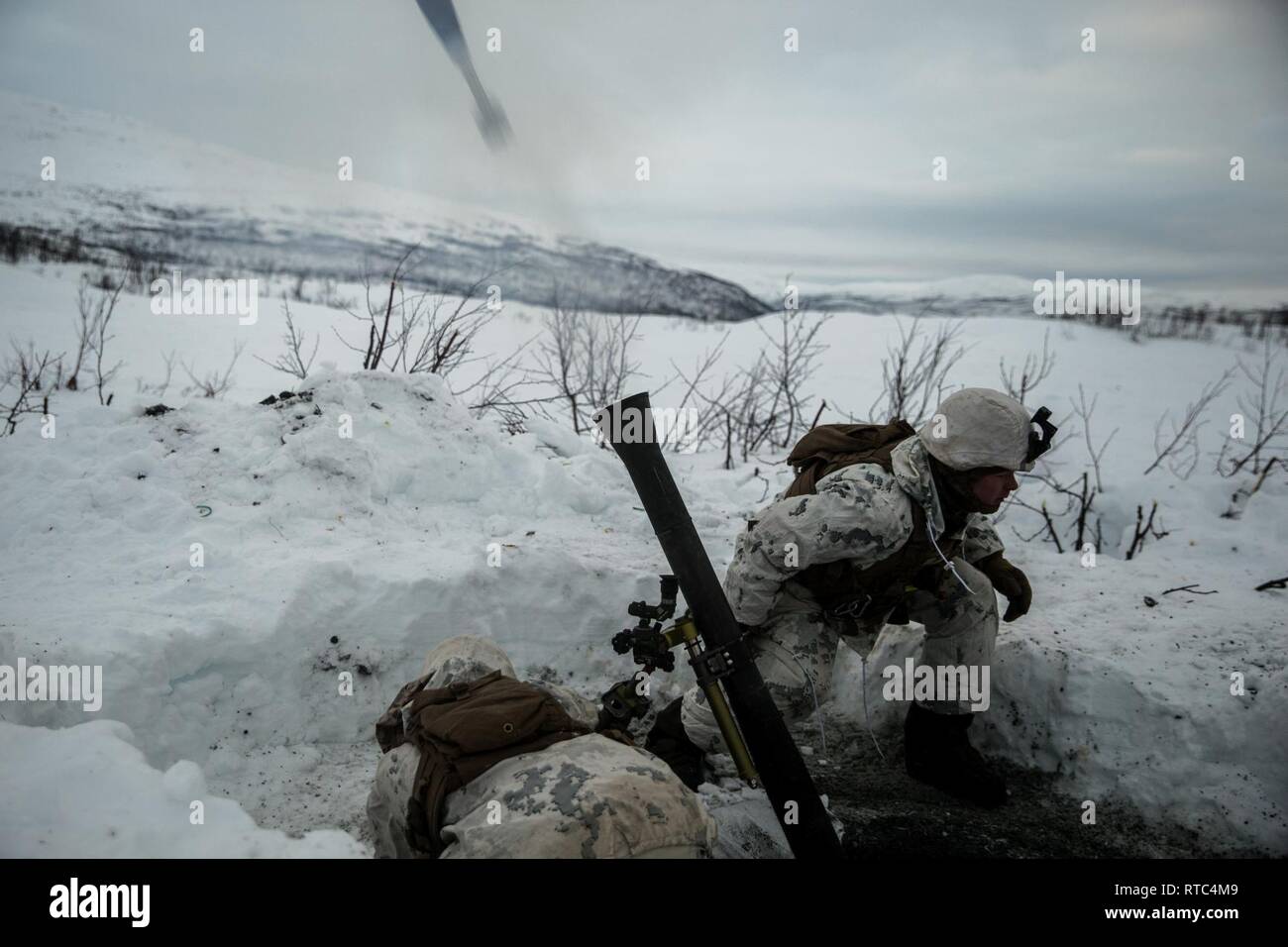 U.S. Marines with Marine Rotational Force-Europe 19.1, Marine Forces Europe and Africa, fire a M252 81 mm mortar system in Setermoen, Norway, Feb. 8, 2019. This training increased MRF-E Marines’ proficiency at cold-weather and mountain-warfare tactical operations in cold-weather environments. Stock Photo