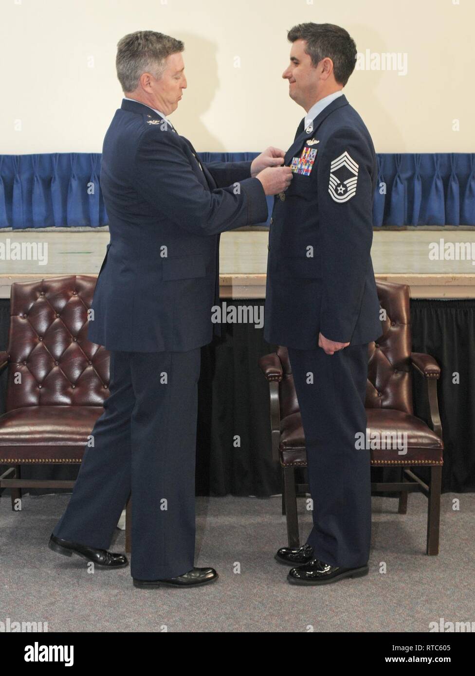 Col. John O’Brien, 111th Attack Wing Operations Group commander, pins a retirement medal on Chief Master Sgt. Robert, 111th Attack Wing Operations Group superintendent, during his retirement ceremony on Feb. 9, 2019 at the main auditorium at Horsham Air Guard Station. Robert was very instrumental in spearheading the MQ-9 Reaper remotely-piloted mission. Stock Photo