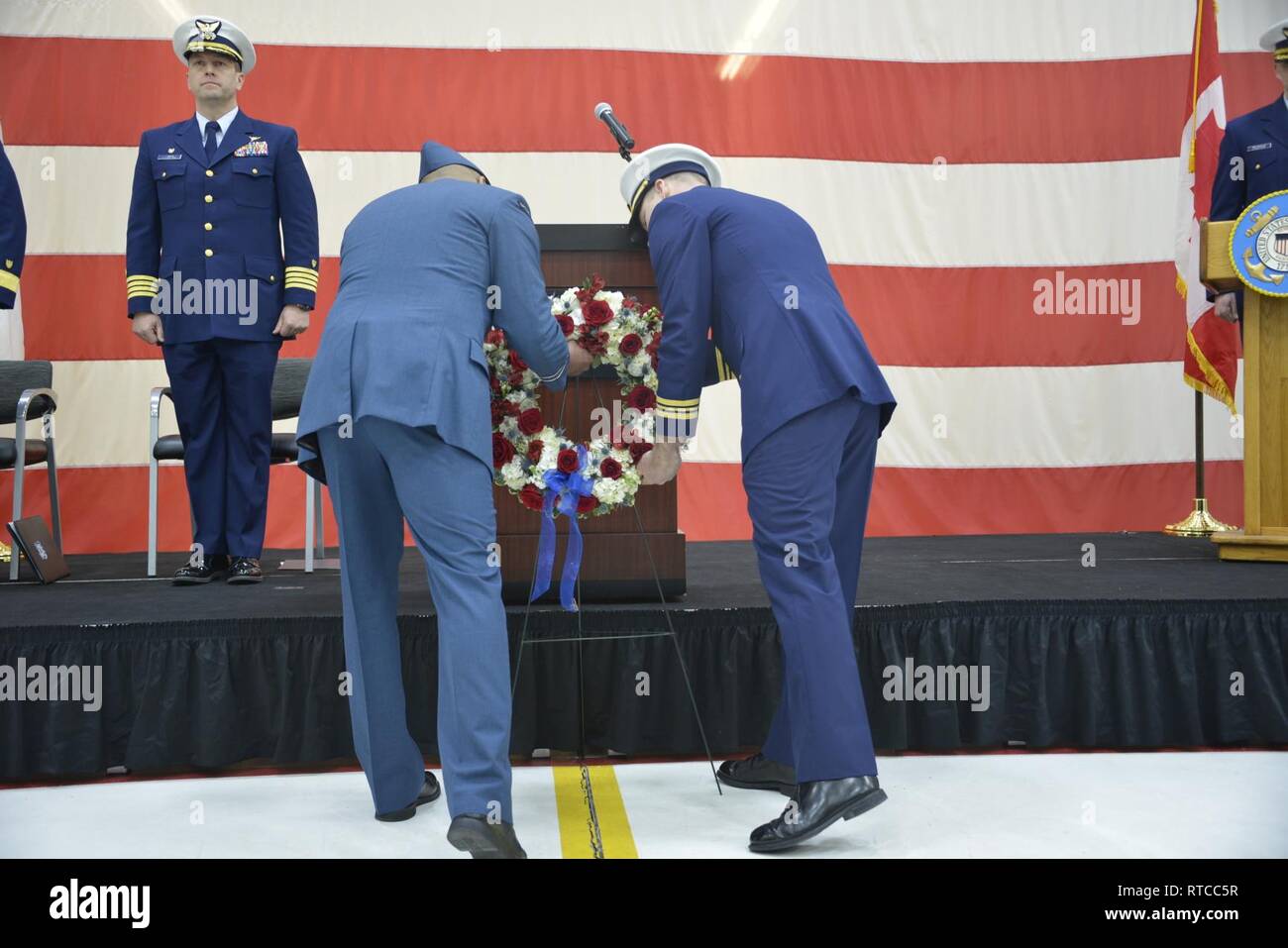 U.S. Coast Guard Lt. Cmdr. John Filipowicz and Royal Canadian Air Force Capt. Pete Wright present the wreath marking the 40th anniversary four aircrew members of Aircraft 1432 gave the ultimate sacrifice, Wednesday, Feb. 13, 2019, Cape Cod, Massachusetts. Both pilots, one crewmember, and a corpsman lost their lives in the accident, while the flight mechanic survived and was rescued by the fishing vessel. Stock Photo