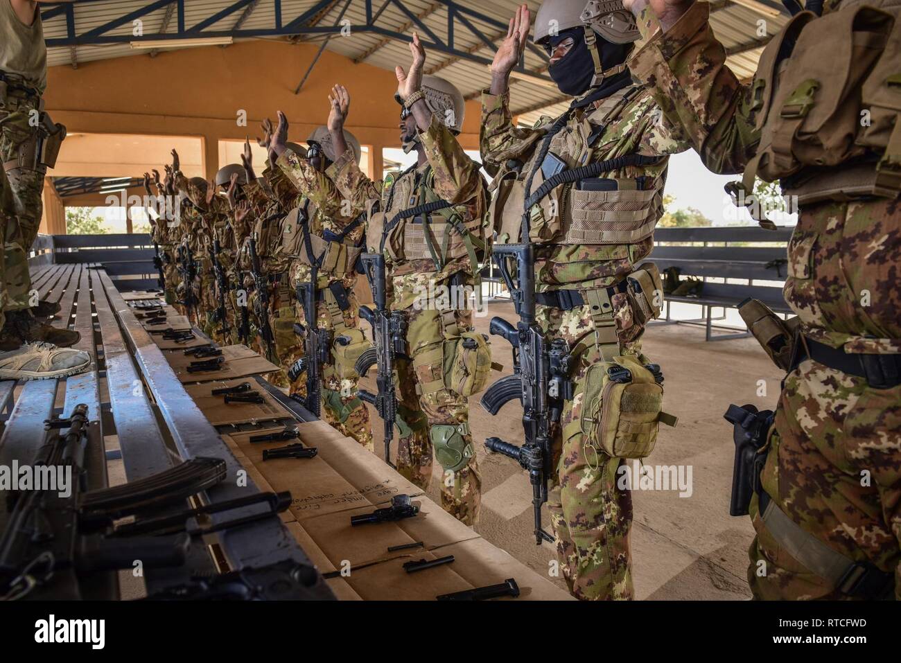 Malian soldiers raise their hands as they wait for the go signal to assemble their handguns in Loumbila, Burkina Faso Feb. 16, 2019. The Malian Soldiers are participating in Flintlock 2019 to enhance various tactical and technical skills. Stock Photo