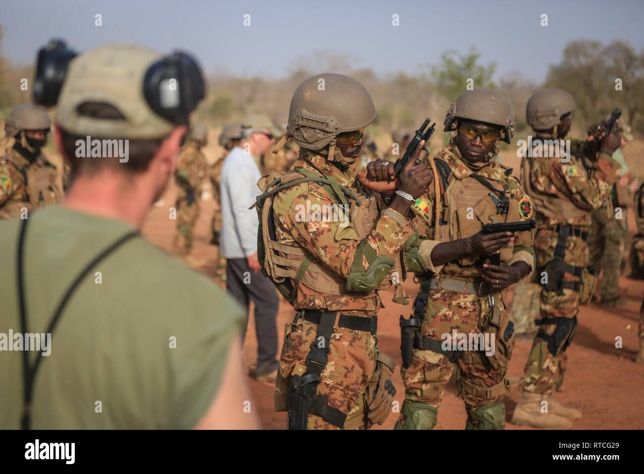 A Czech Special Forces Soldier observes Malian soldiers as they clear M9 pistols during a live fire range near Loumbila, Burkina Faso Feb. 17, 2019. The training event is part of exercise Flintlock 19 and ensures the Malian Soldiers are proficient with their weapons. Flintlock is U.S. Africa Command's premier and largest special operations forces exercise in Africa. Stock Photo