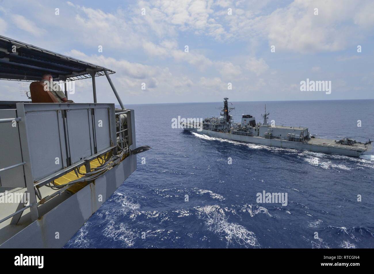 GULF OF THAILAND (Feb. 18 ,2019) Civilian Mariner Kevin Sauls, Ship’s Master aboard the Henry J. Kaiser-class fleet replenishment oiler USNS Guadalupe (T-AO 200), observes the Duke-class frigate HMS Montrose (F 236) during a replenishment-at-sea drill. Guadalupe is conducting operations, providing logistical support to U.S. Navy and allied forces operating in the U.S. 7th Fleet area of responsibility. Stock Photo