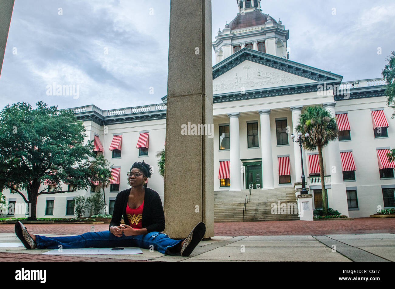 A woman sits outside the Florida state capitol in Tallahassee, Florida, protesting Florida's stand-your-ground and racial profiling laws. Stock Photo
