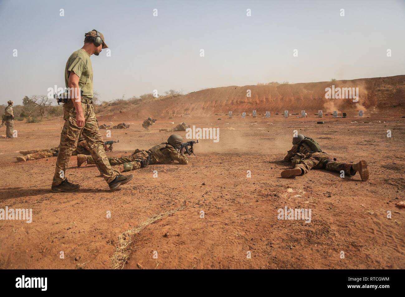 A Czech Special Forces Soldier observes Malian soldiers as they fire their AK-47 rifles near base camp Loumbila, in Burkina Faso on Feb. 19, 2019. The training event is part of exercise Flintlock 2019 and enhances the Malian Soldiers proficiency with their weapons and battle movements. Flintlock is U.S. Africa Command's premier special operations forces exercise in Africa. Stock Photo