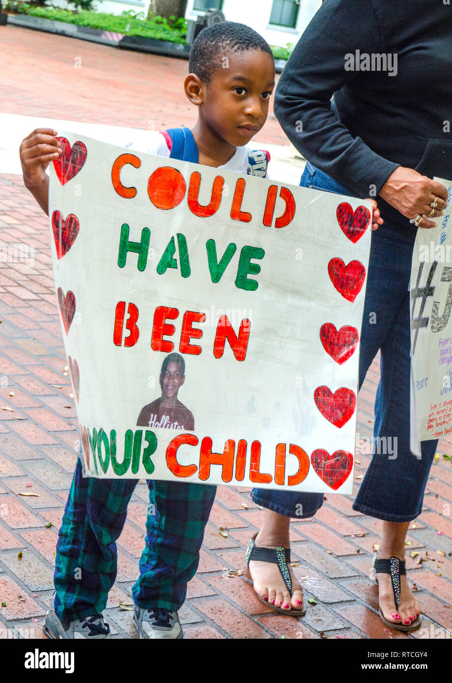 Sevyn Coleman, 5, stands outside the Florida Capitol building in Tallahassee, with a sign featuring an image of 17-year-old Trayvon Martin. Stock Photo