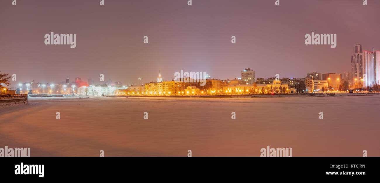 Winter night on the banks of the pond in the city center. Illuminated ...
