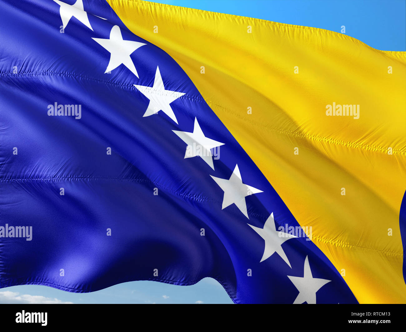 Flag of Bosnia and Herzegovina waving in the wind against deep blue sky ...