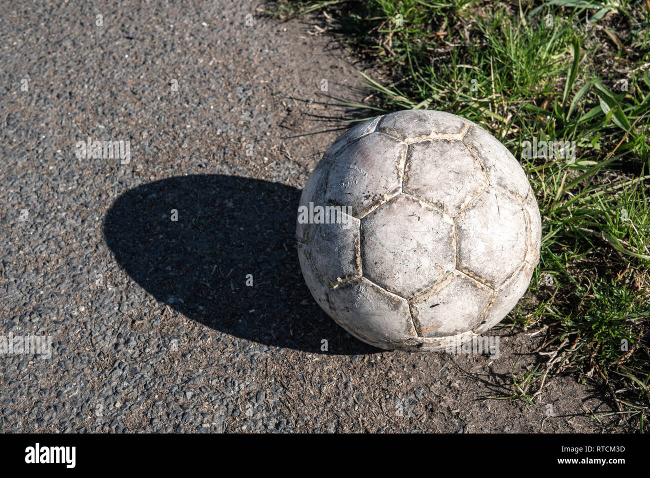 Aged white soccer ball on asphalt road Stock Photo Alamy
