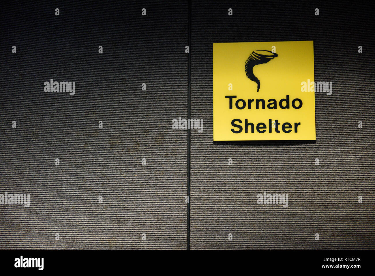 Tornado shelter yellow sign designating a safe room area, with tornado or twister icon Stock Photo