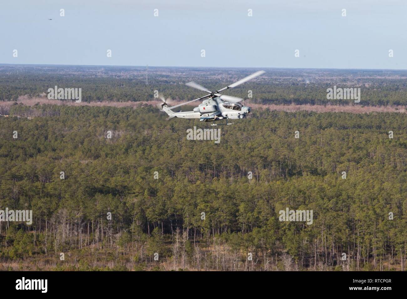 A U.S. Marine Corps AH-1Z Viper flies during an aerial training exercise at Marine Corps Air Station New River, North Carolina, Feb. 14, 2019. Marine Light Attack Helicopter Squadron (HMLA) 167 conducted a live-fire exercise using the GAU-17/A minigun and GAU-21 .50 caliber machine gun to improve weapons proficiency. The aircraft is assigned to HMLA-167, Marine Aircraft Group 29, 2nd Marine Aircraft Wing. Stock Photo