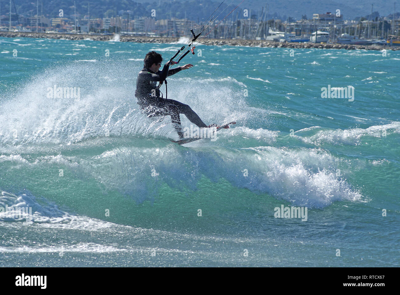 Kite boarder surfing a wave during a windy day at the end of winter in French riviera. (St Laurent du Var spot) Stock Photo