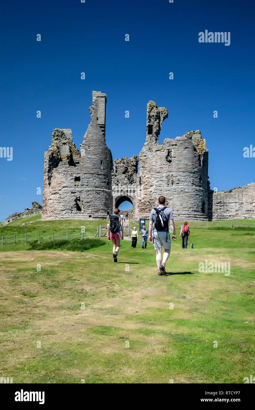 Hikers at Dunstanburgh Castle, England, United Kingdom Stock Photo