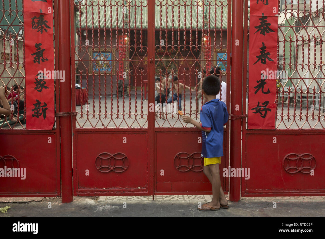 Young boy looking kids playing soccer in chinese temple yard. Stock Photo