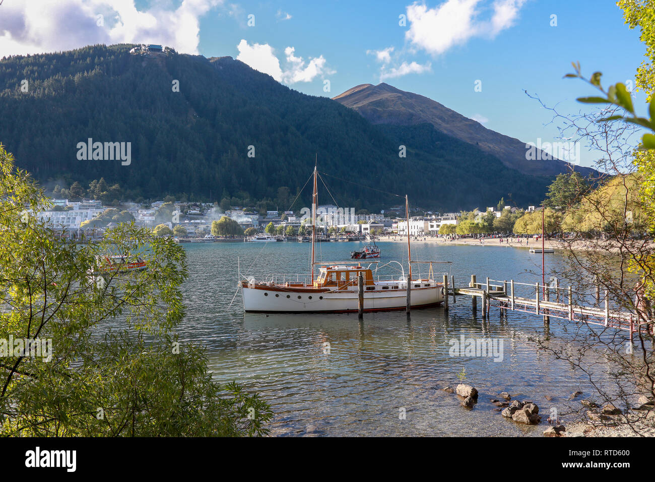 Sailing boat and tender tied to jetty in Lake Wakatipu, Queenstown harbour New Zealand South Island Stock Photo