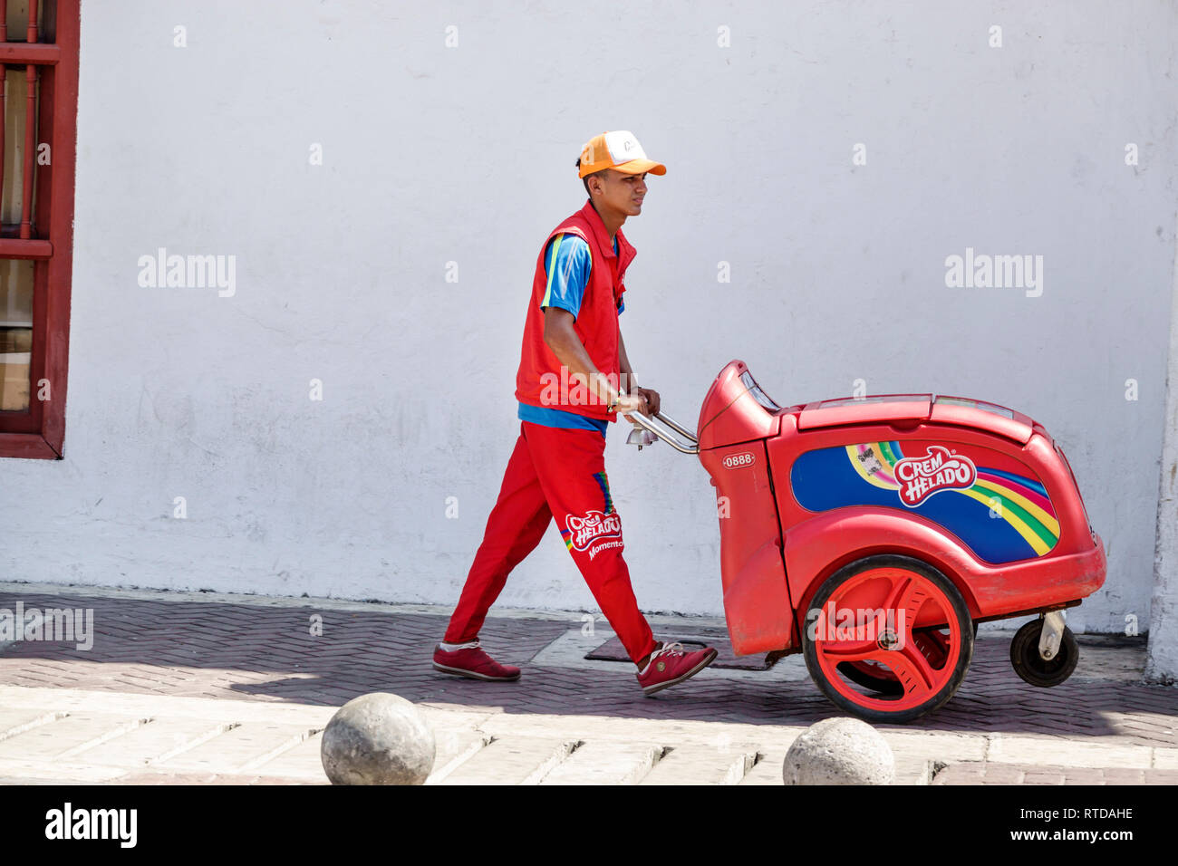 Cartagena Colombia,Hispanic resident residents,ice cream rolling cart vendor Crem Helado,man men male,young adult,pushing,uniform,working,COL190119107 Stock Photo