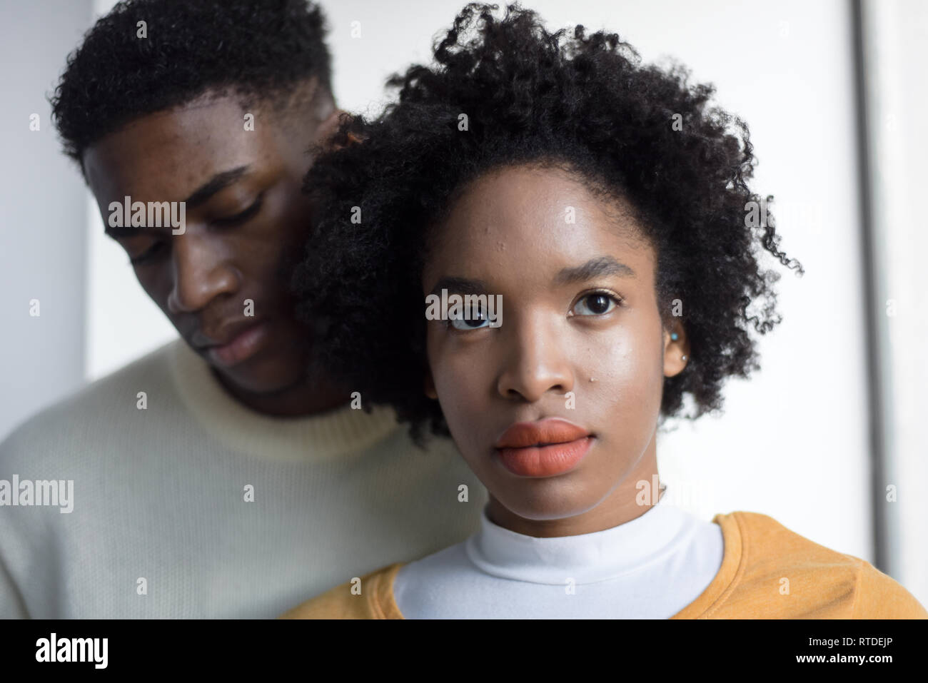 A Young Attractive Black Couple Looking Serious In A Simple White