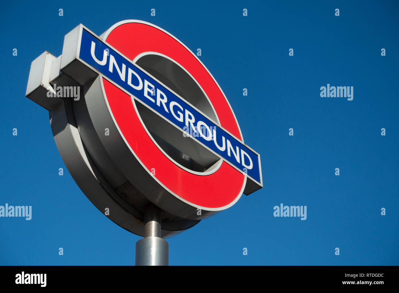 Close up of a contemporary tube sign for the London Underground transportation systems in London against a blue sunny sky Stock Photo