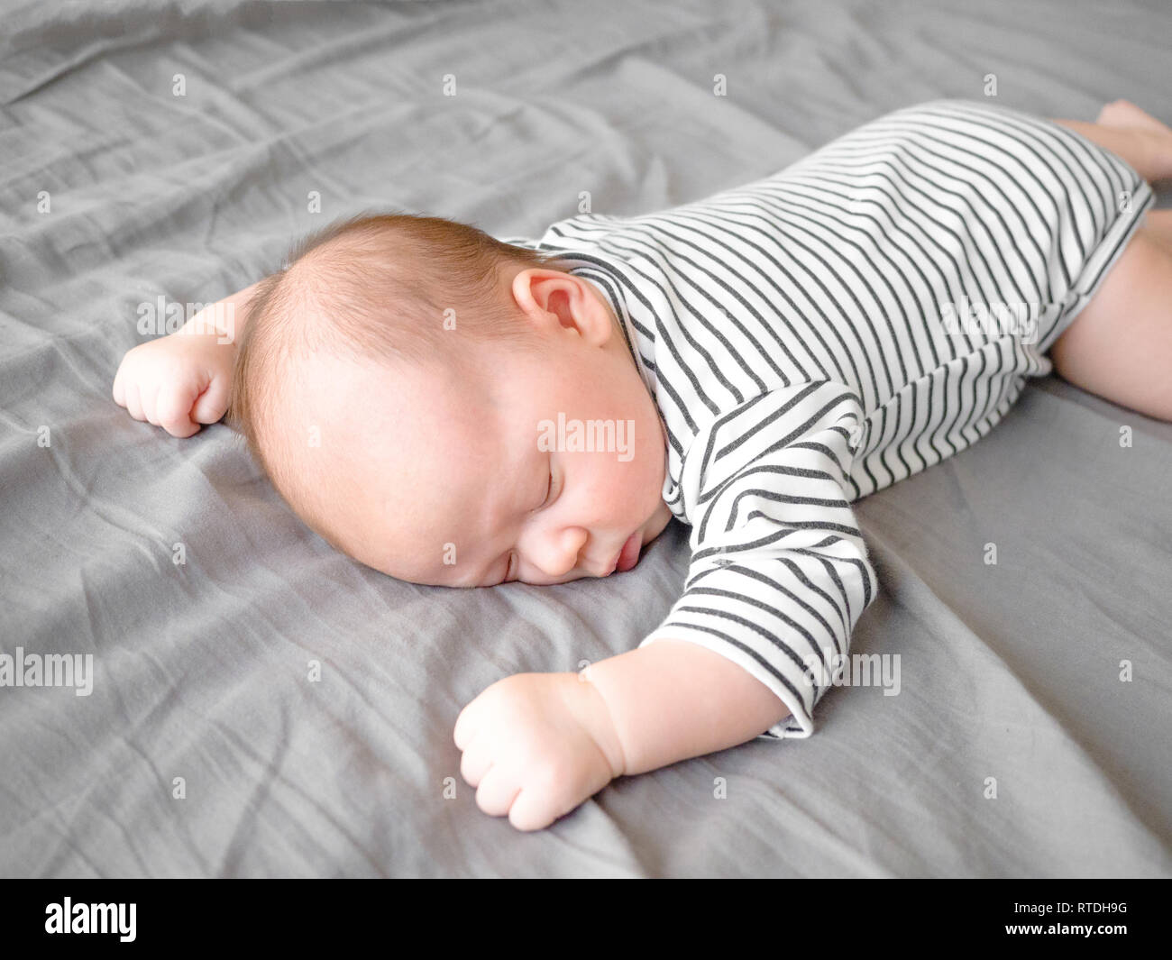Close-up portrait cute little mixed race Asian and Caucasian baby son sleeping on back. Daytime sleeping. Family, healthy birth concept photo Stock Photo