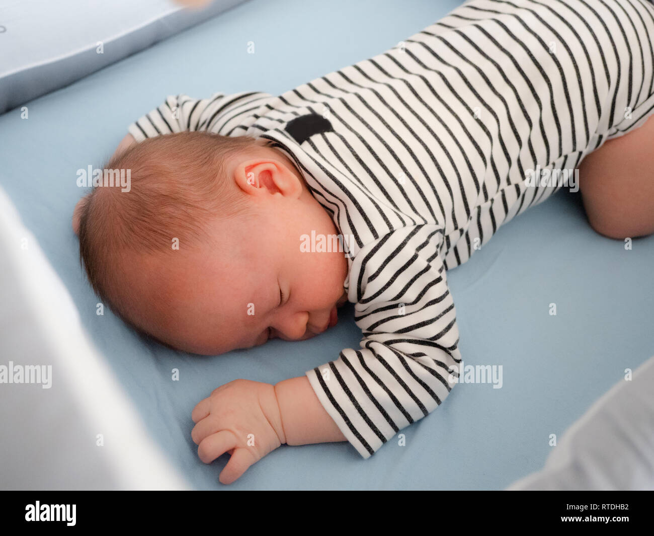 Close-up portrait cute little mixed race Asian and Caucasian baby son sleeping on back. Daytime sleeping. Family, healthy birth concept photo Stock Photo