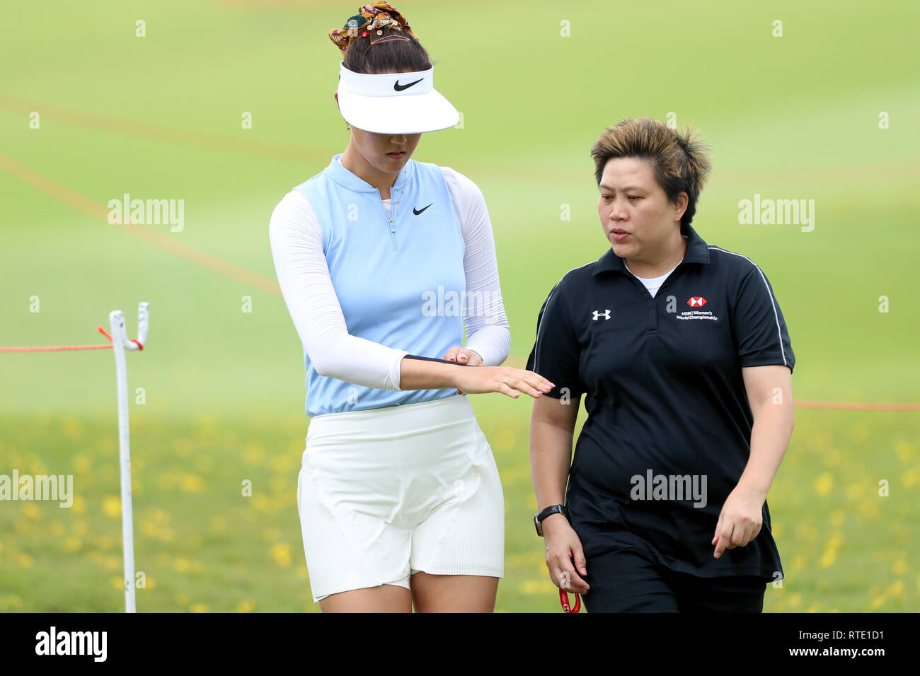 Singapore. 28th Feb, 2019. Michelle Wie, left, of the United States receives treatment to her wrist on the 10th hole during the first round of the Women's World Championship at the Tanjong Course, Sentosa Golf Club. Credit: Paul Miller/ZUMA Wire/Alamy Live News Stock Photo