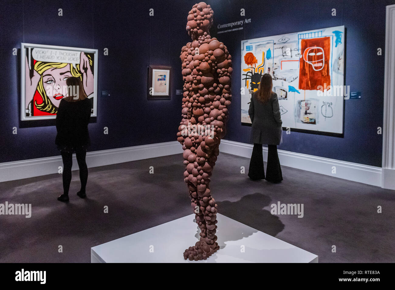 London, UK. 1st Mar 2019. Standing Matter XII by Antony Gormley, est £250-350,000 with, in the background, Roy Lichtenstein, Vicki! I--I Thought I Heard Your Voice, 1964, Est. £5,000,000-7,000,000 and Jean-Michel Basquiat, Apex, 1986, Estimate £5-7m  - A preview ahead of the Sotheby’s Contemporary Art Evening Auction at Sotheby's New Bond Street, London. The auction will take place on 5 March. Credit: Guy Bell/Alamy Live News Stock Photo