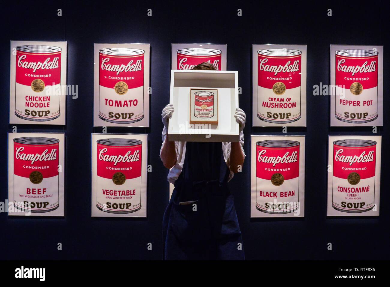 London, UK. 1st Mar, 2019. A art handler holds Andy Warhol 'Little Campbell's Soup Can' Estimate £1,500,000- 2,000,000. Background Andy Warhol Campbell Soup I Estimate £300,000- 400,000. The sale is on the 5th March . Credit: claire doherty/Alamy Live News Stock Photo