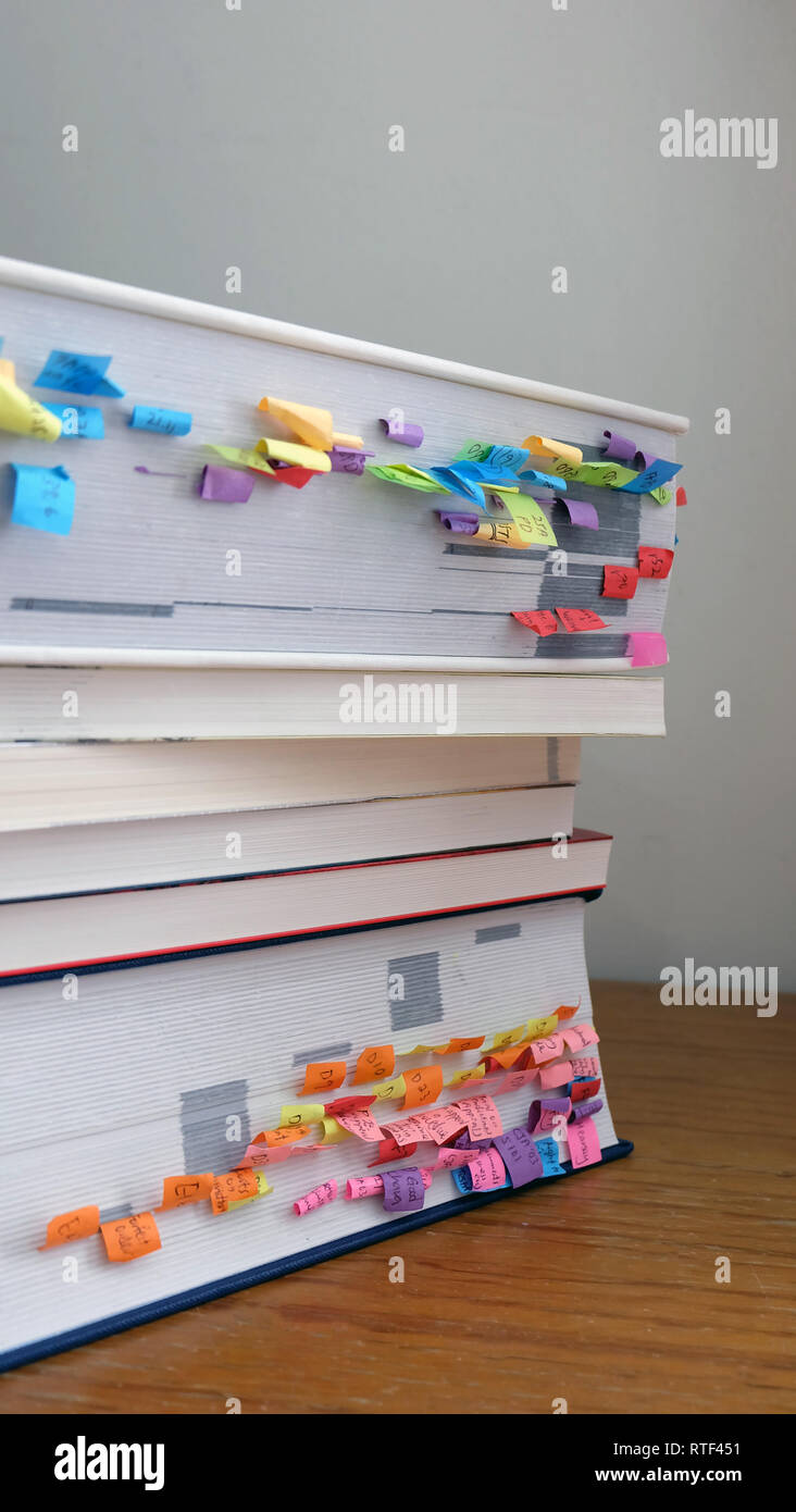 Stack of books with colorful paper markings on the side of the books. Stock Photo