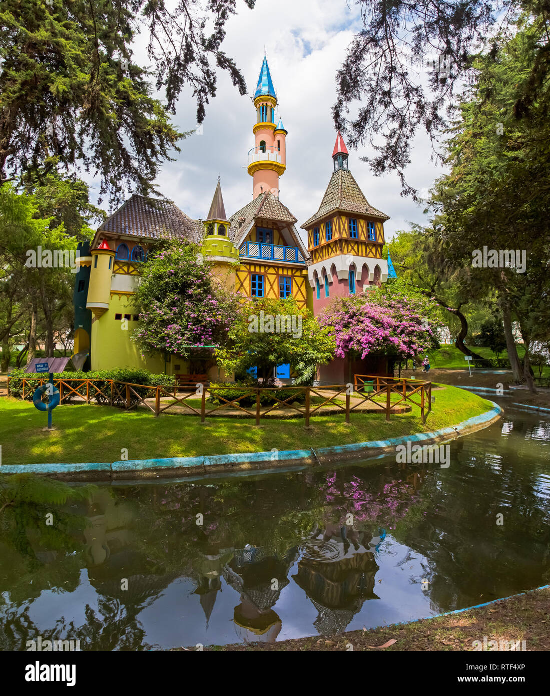 LOJA, ECUADOR, March 2018: Replica of a European medieval castle surrounded by trees, flowers and a water channel, inside the Jipiro recreational park Stock Photo