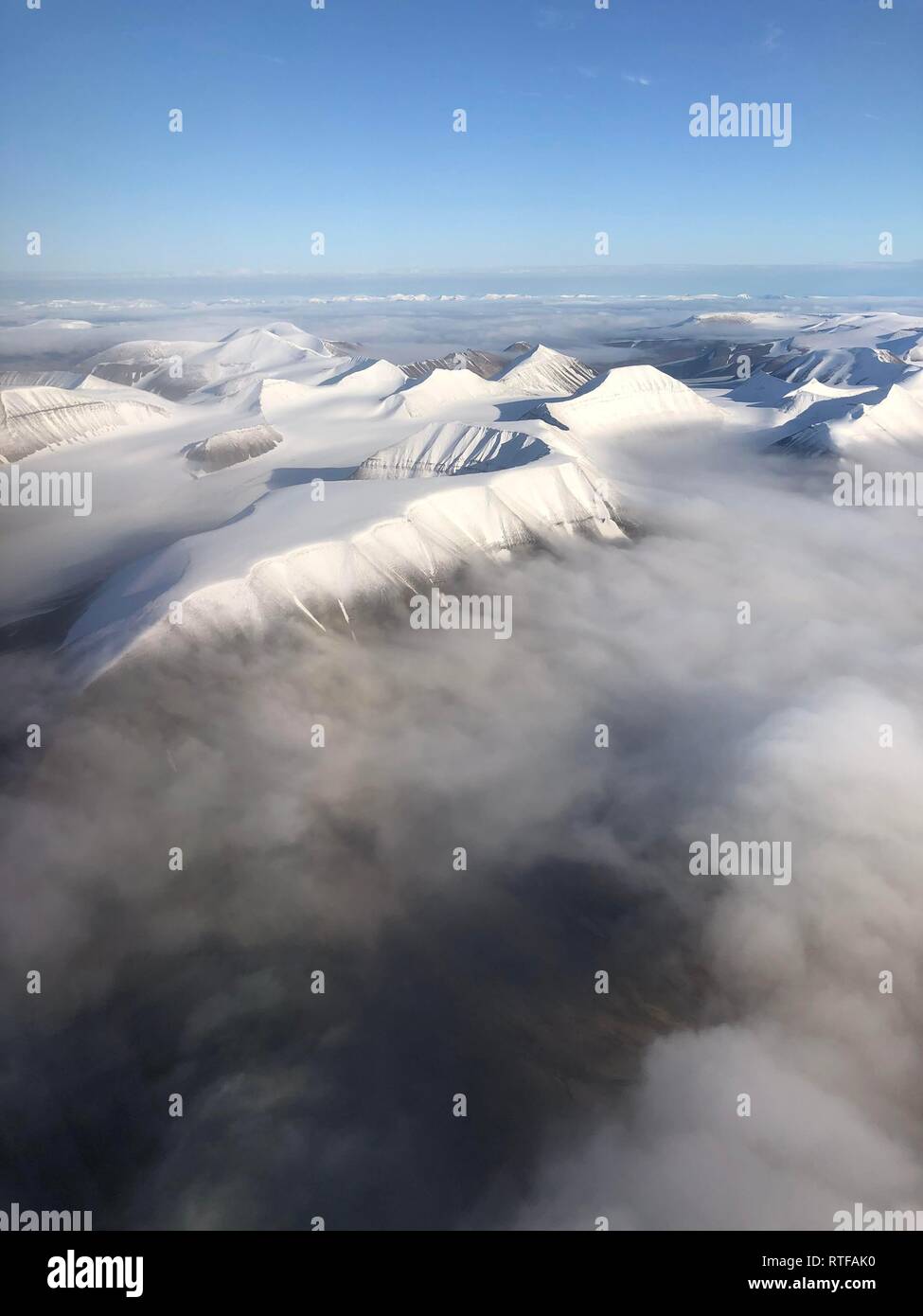 Aerial view, mountain peak with snow above cloud cover, Spitsbergen, Svalbard, Norway Stock Photo