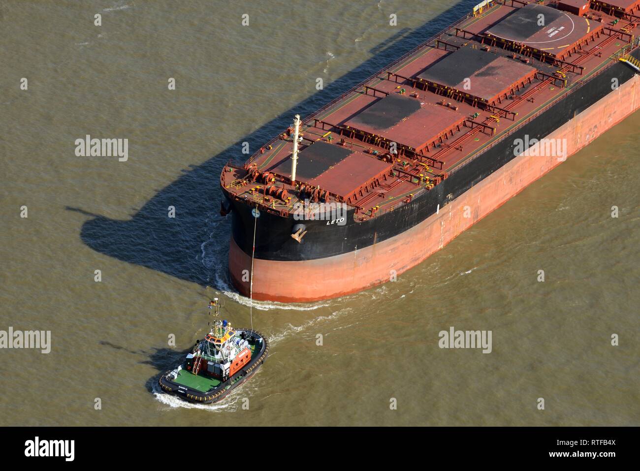 Aerial view, tug manoeuvres cargo ship, Hamburg, Germany Stock Photo
