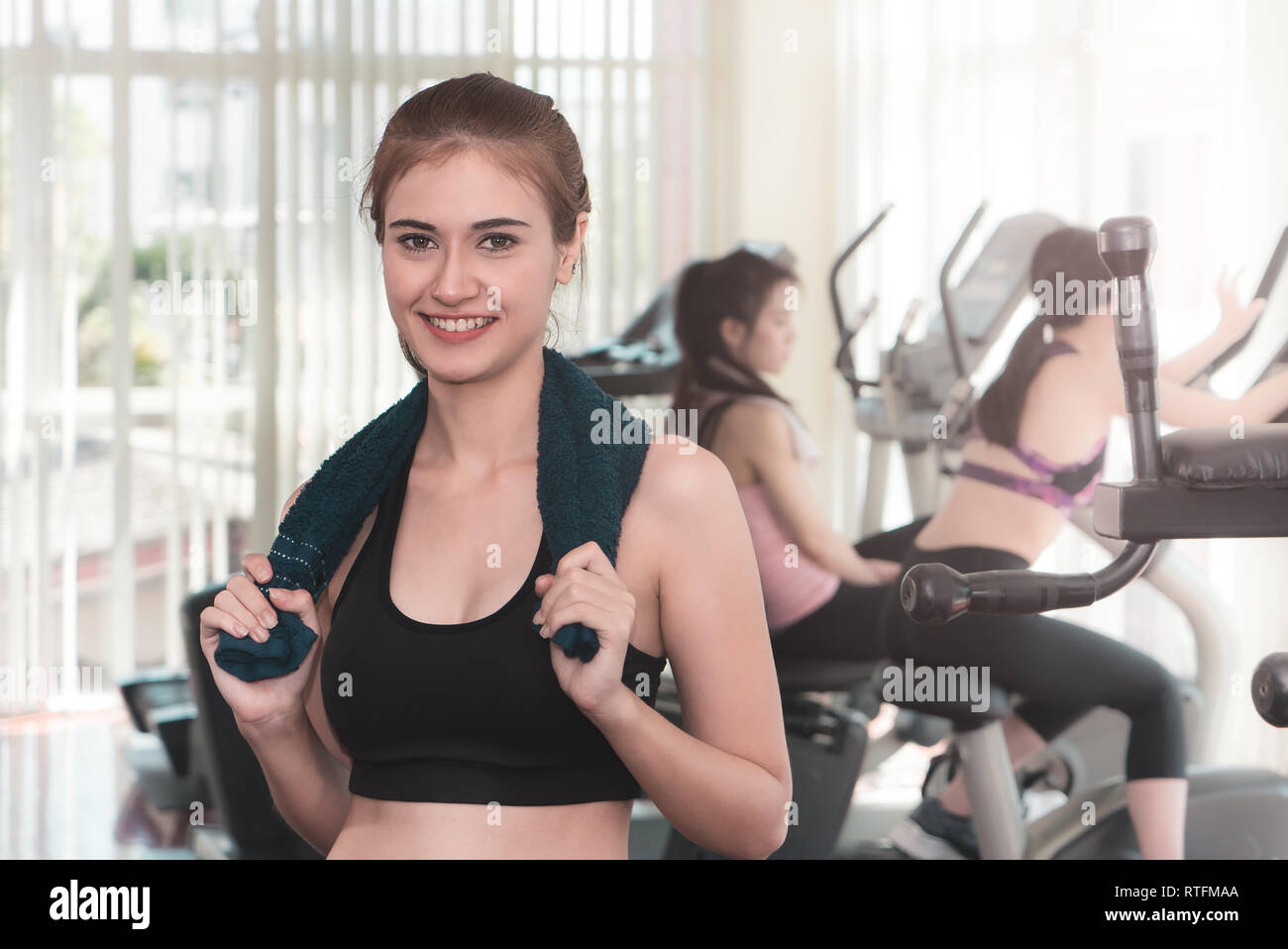 Portrait of a sporty woman standing in fitness gym with towel Stock ...