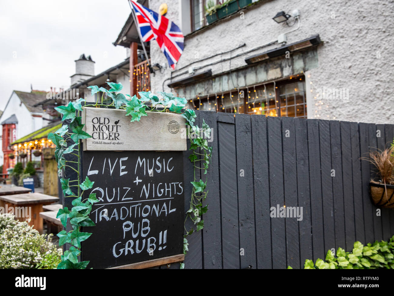 English pub in Bowness on windermere flying the union jack and advertising live music and quiz nights, Lake District,Cumbria,England Stock Photo