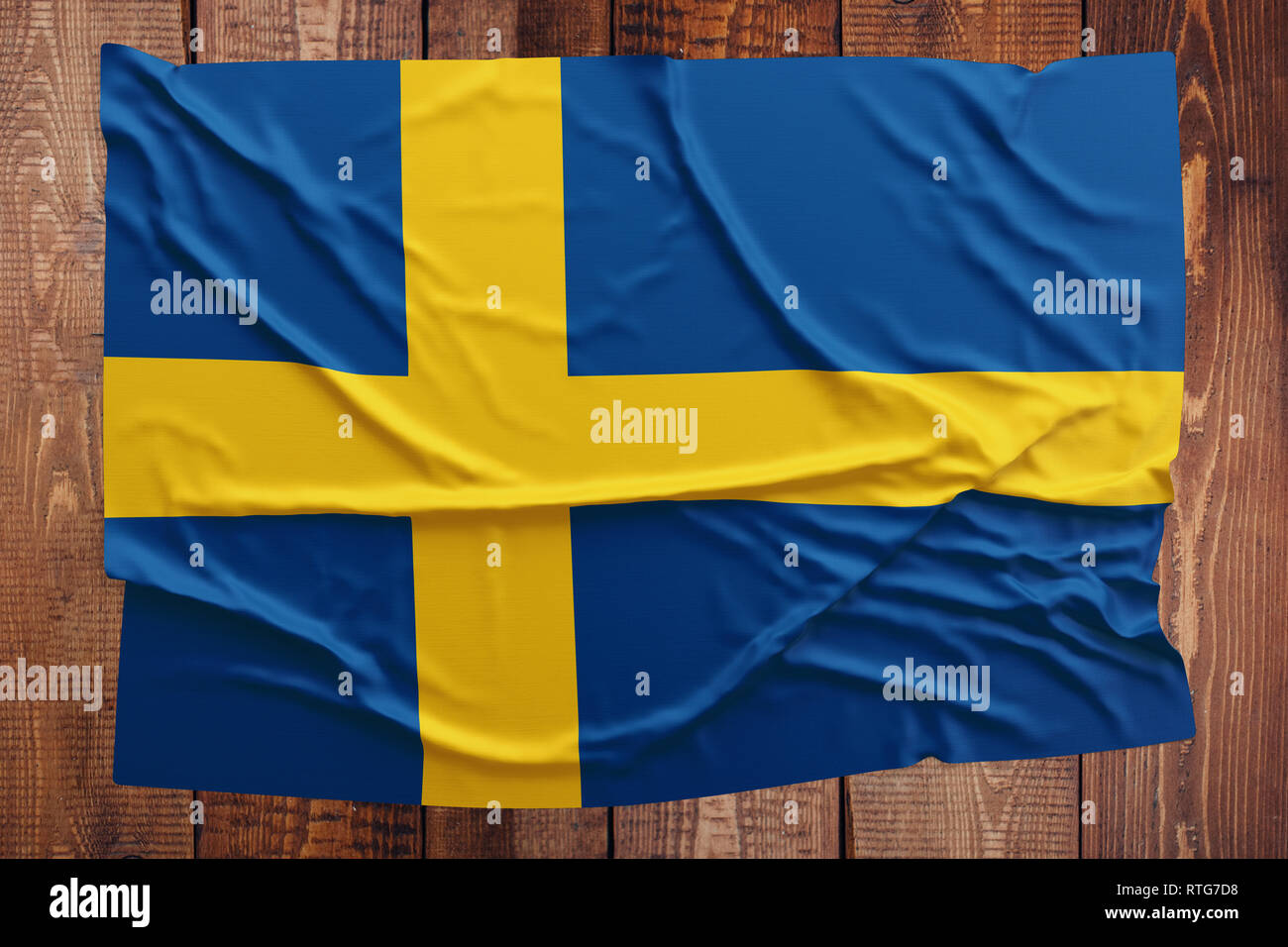 Flag of Sweden on a wooden table background. Wrinkled Swedish flag top view. Stock Photo