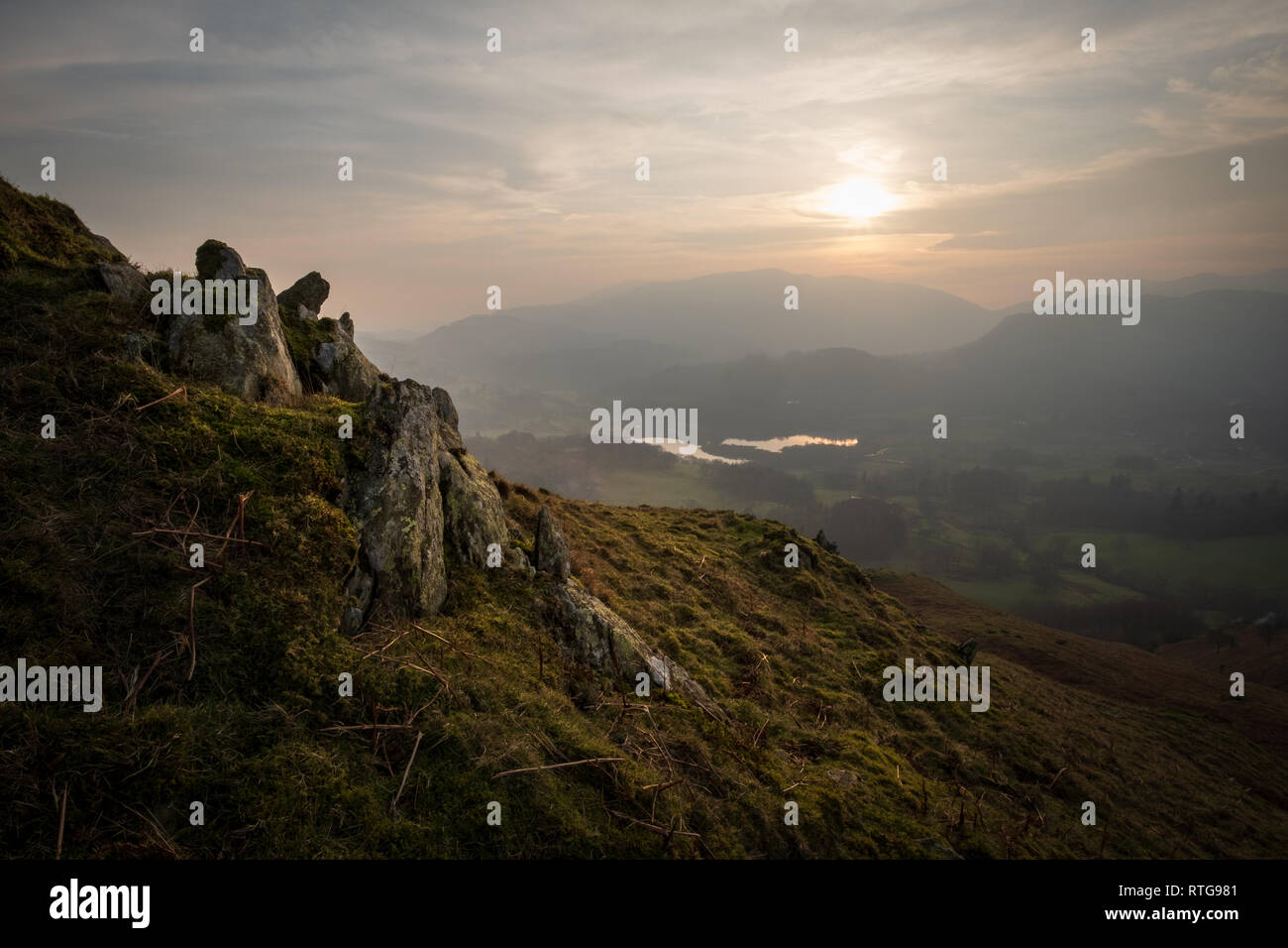 Sunset over Elter Water seen from the summit of Loughrigg Fell, Wetherlam is in the distance, Lake District, UK Stock Photo