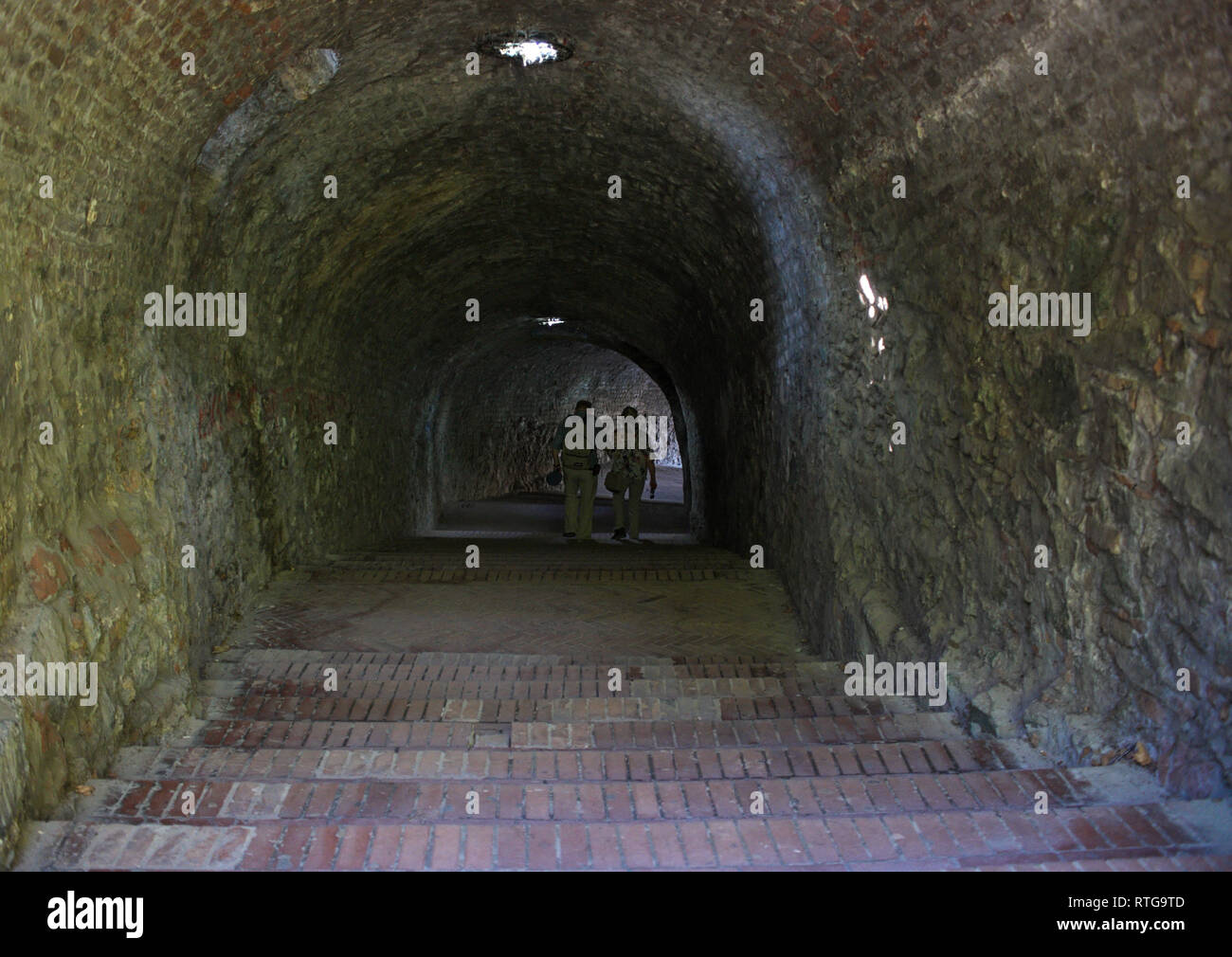 Elderly couple walking through a dark tunnel Stock Photo