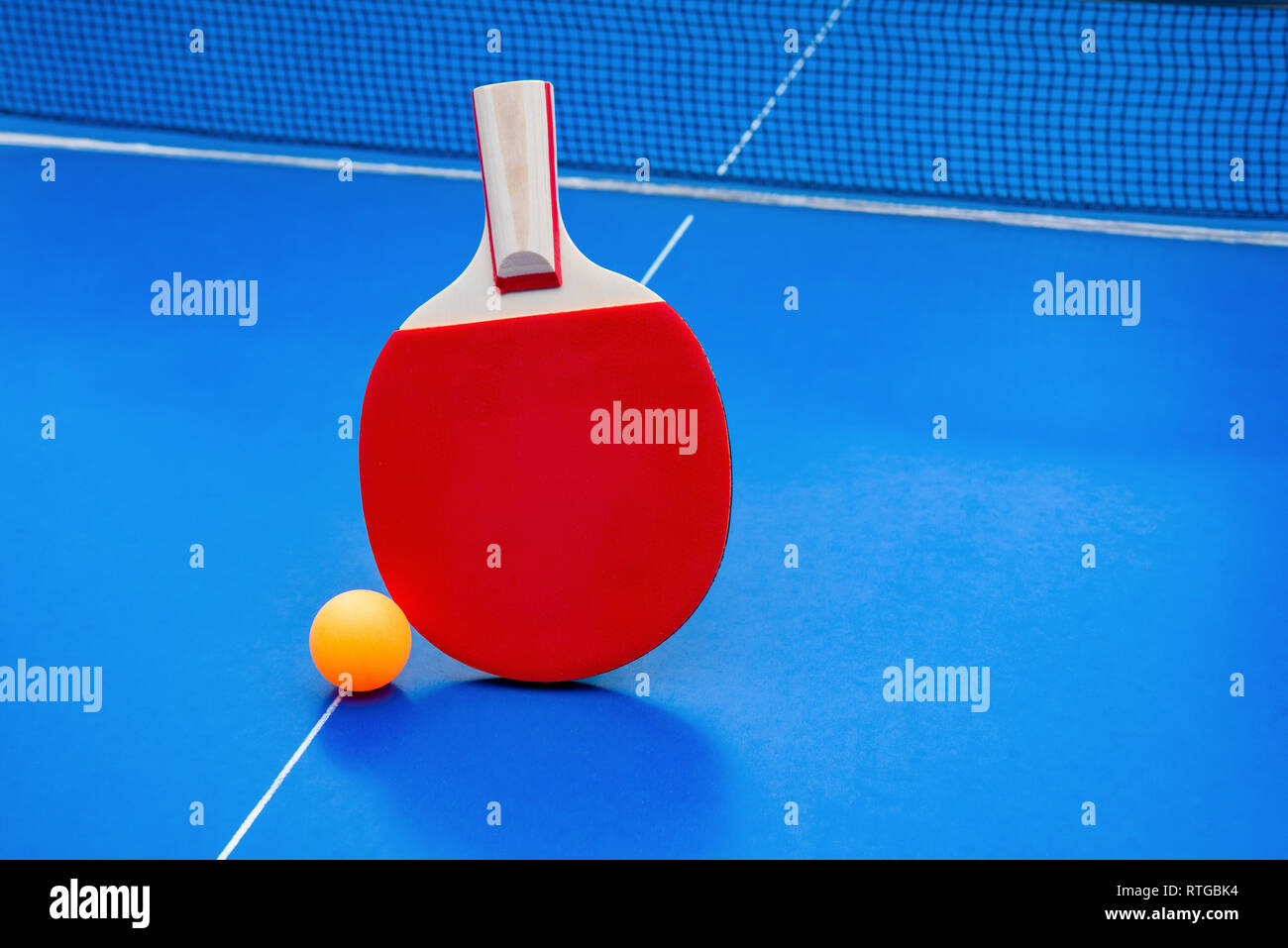 pingpong racket and ball and net on a blue pingpong table Stock Photo